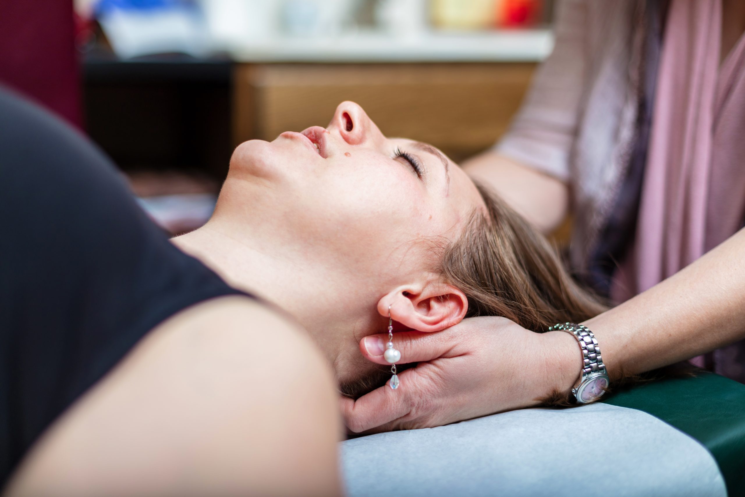 Woman receiving CranioSacral Therapy on plinth Woman receiving CranioSacral Therapy on plinth